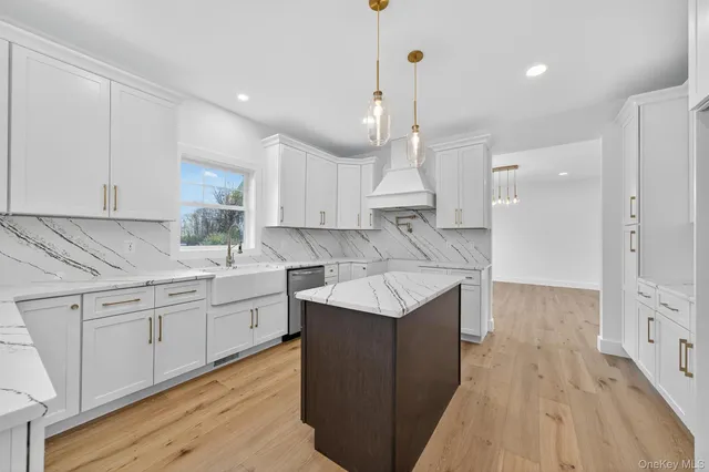 a kitchen with white cabinets appliances and wooden floor