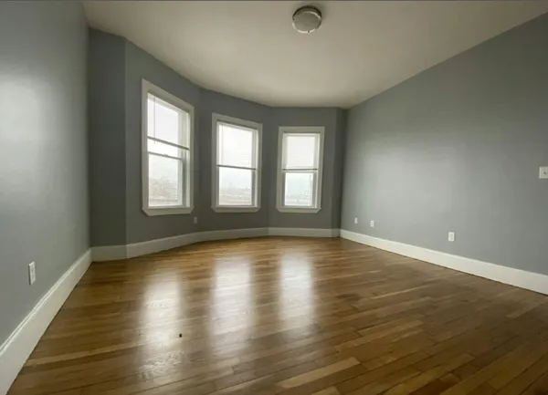 a view of empty room with wooden floor