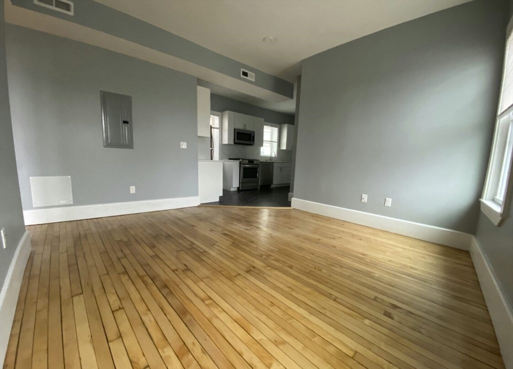 301 Hancock Street, Unit 2 Boston, MA 02125 - Photo 10 of 11 wooden floor in an empty room with a fireplace