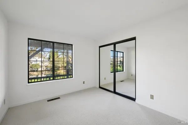 an empty room with windows and closet