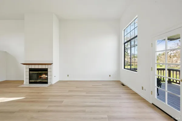 wooden floor fireplace and windows in an empty room