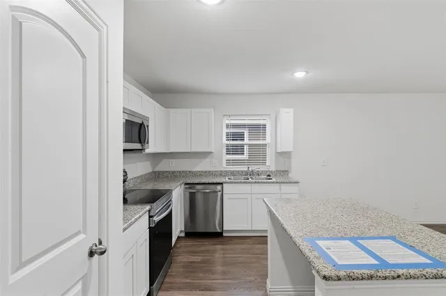 a kitchen with a sink stove and cabinets