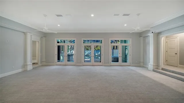 a view of an empty room with glass door and balcony