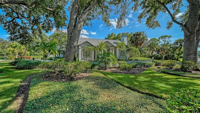 a front view of a house with a garden and trees