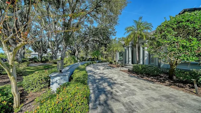 a front view of a house with a garden and trees