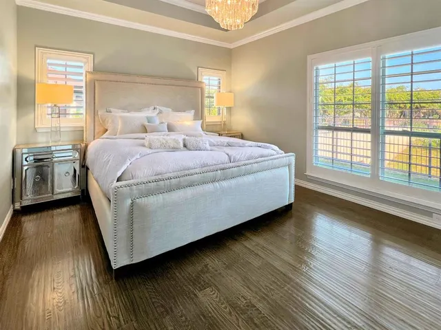 a spacious bedroom with a bed and wooden floor