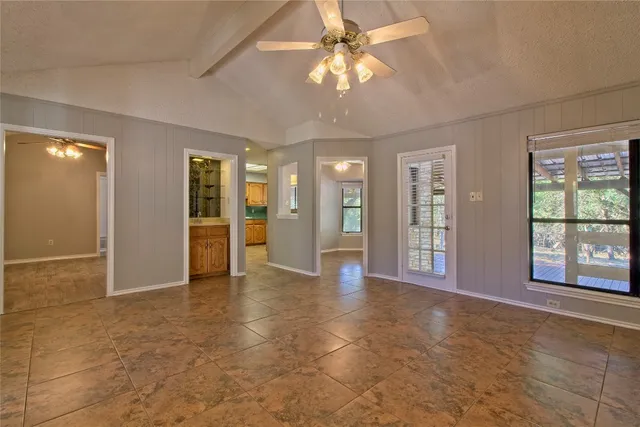 a view of an empty room with a fireplace and a window