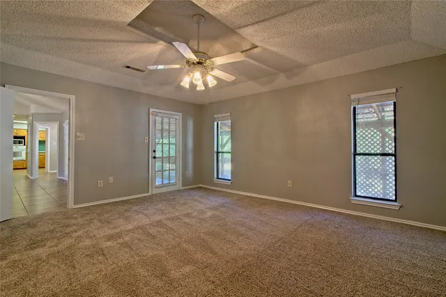 a view of an empty room with a chandelier fan