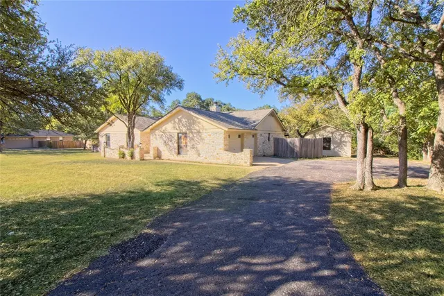 a view of a backyard with large trees