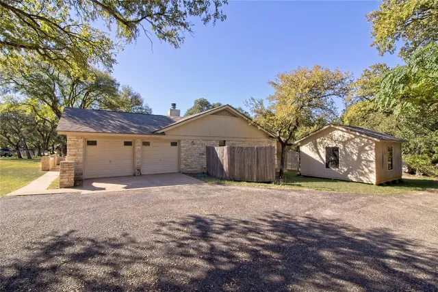 a view of an empty room with chandelier fan and fire place
