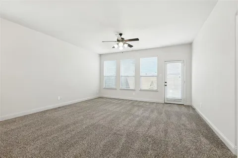 an empty room with a window and a ceiling fan