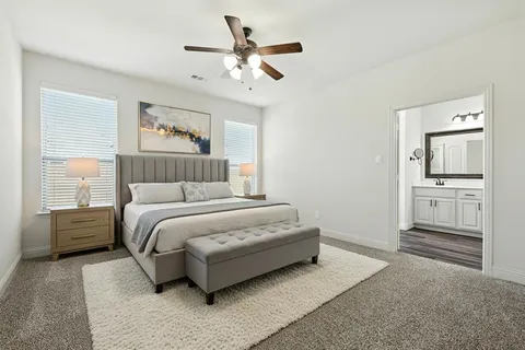 a bedroom with a large bed and ceiling fan
