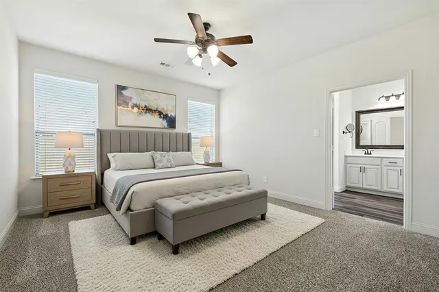 a bedroom with a large bed and ceiling fan