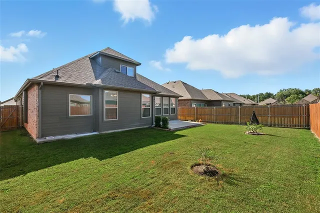 a backyard of a house with table and chairs