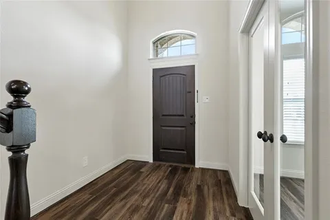 a view of a hallway with wooden floor and front door