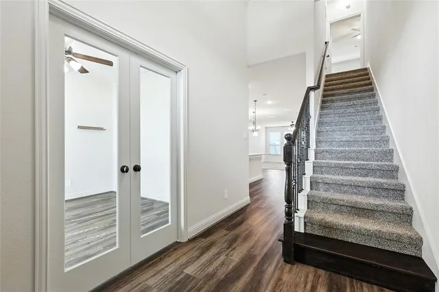 a view of a hallway with wooden floor and entryway