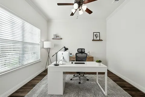 a view of a workspace with furniture and a window