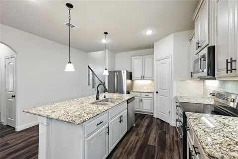a kitchen with a stove sink and refrigerator