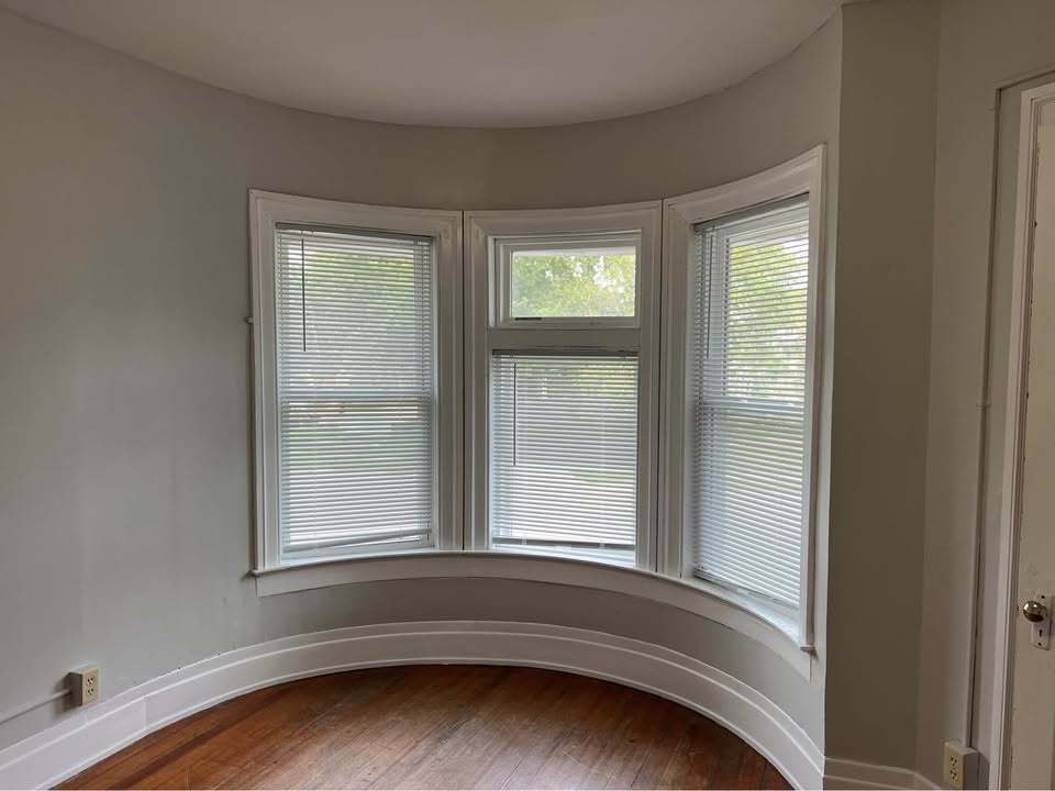 220 College Avenue, Unit 2 DeKalb, IL 60115 - Photo 12 of 14 a view of an empty room with wooden floor and a window