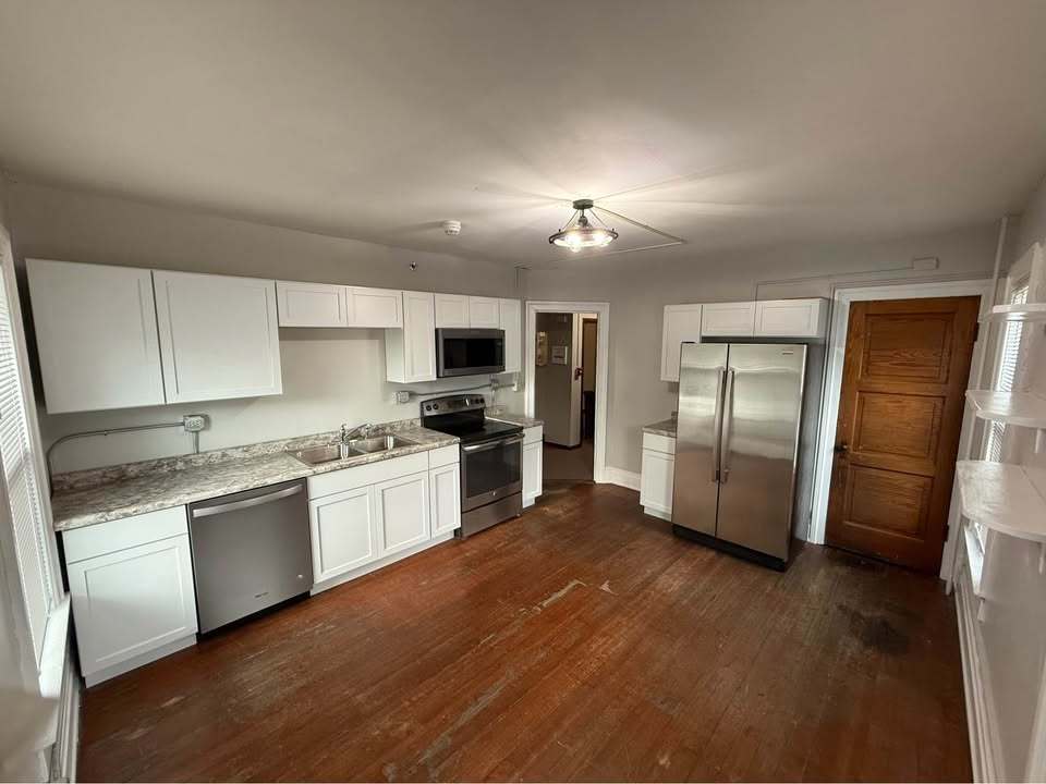 220 College Avenue, Unit 2 DeKalb, IL 60115 - Photo 5 of 14 a kitchen with granite countertop stainless steel appliances and wooden cabinets
