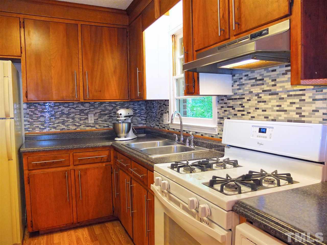 6808 Laurdane Road Raleigh, NC 27613 - Photo 3 of 25 a kitchen with a sink stove and cabinets