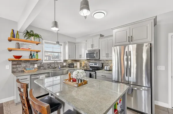 a kitchen with refrigerator a stove a sink dishwasher a oven with a dining table and chairs with wooden floor