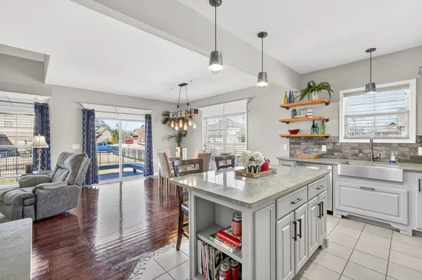 a open kitchen with stainless steel appliances granite countertop a stove oven a sink dishwasher and white cabinets with wooden floor