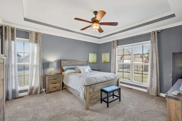 a bedroom with a bed and a ceiling fan