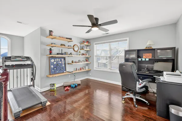 a view of a workspace with furniture and a window
