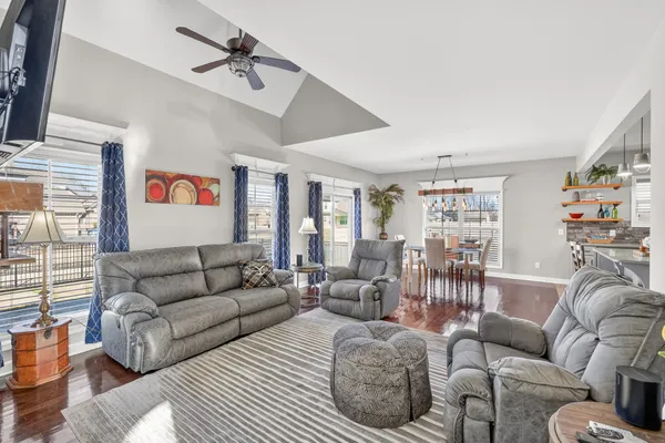 a living room with furniture ceiling fan and a window