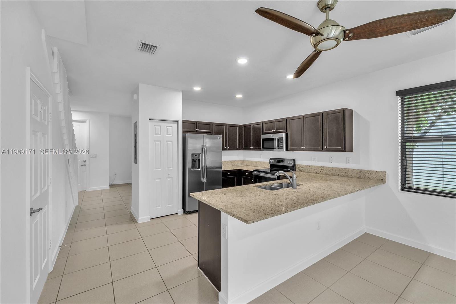 11563 Southwest 248th Lane Homestead, FL 33032 - Photo 12 of 28 a kitchen with stainless steel appliances granite countertop a sink and a refrigerator