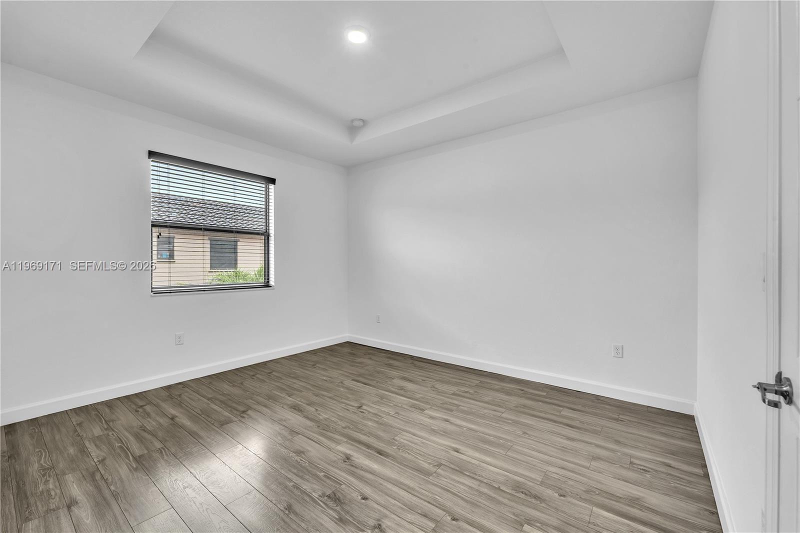 11563 Southwest 248th Lane Homestead, FL 33032 - Photo 15 of 28 a view of an empty room with wooden floor and a window