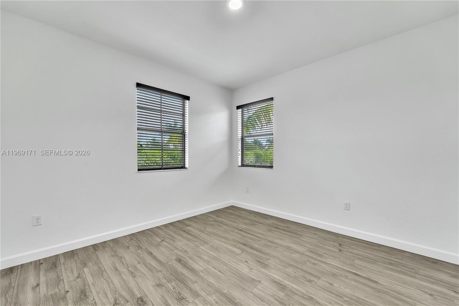 11563 Southwest 248th Lane Homestead, FL 33032 - Photo 20 of 28 an empty room with wooden floor and windows