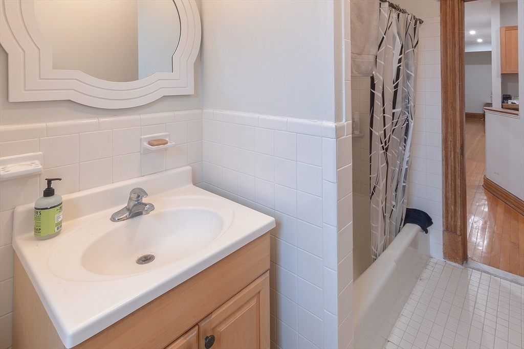 50 St Paul Street, Unit 4 Brookline, MA 02446 - Photo 14 of 21 a bathroom with a sink a mirror and shower