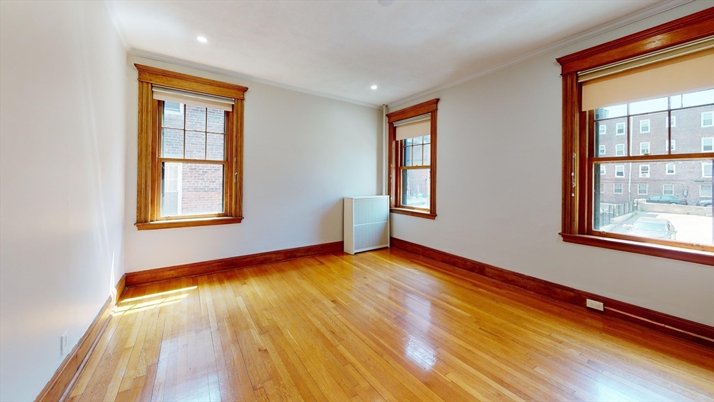 50 St Paul Street, Unit 4 Brookline, MA 02446 - Photo 8 of 21 a view of an empty room with window and wooden floor