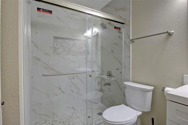 a white toilet sitting next to a bath tub shower