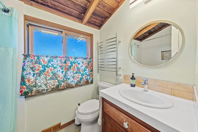 a view of a street with potted plants and large trees