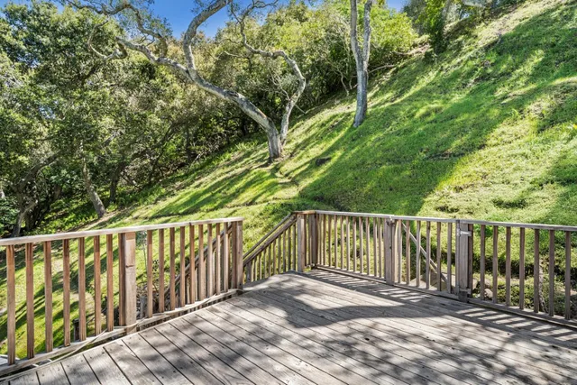 a balcony with wooden floor and fence