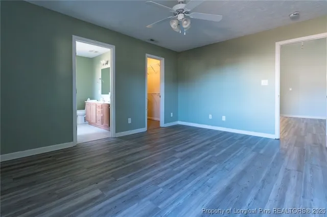 an empty room with wooden floor and chandelier fan