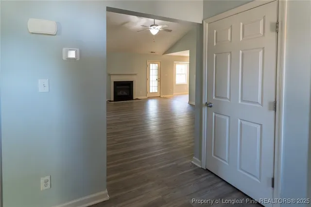 a view of a hallway with wooden floor and a fireplace