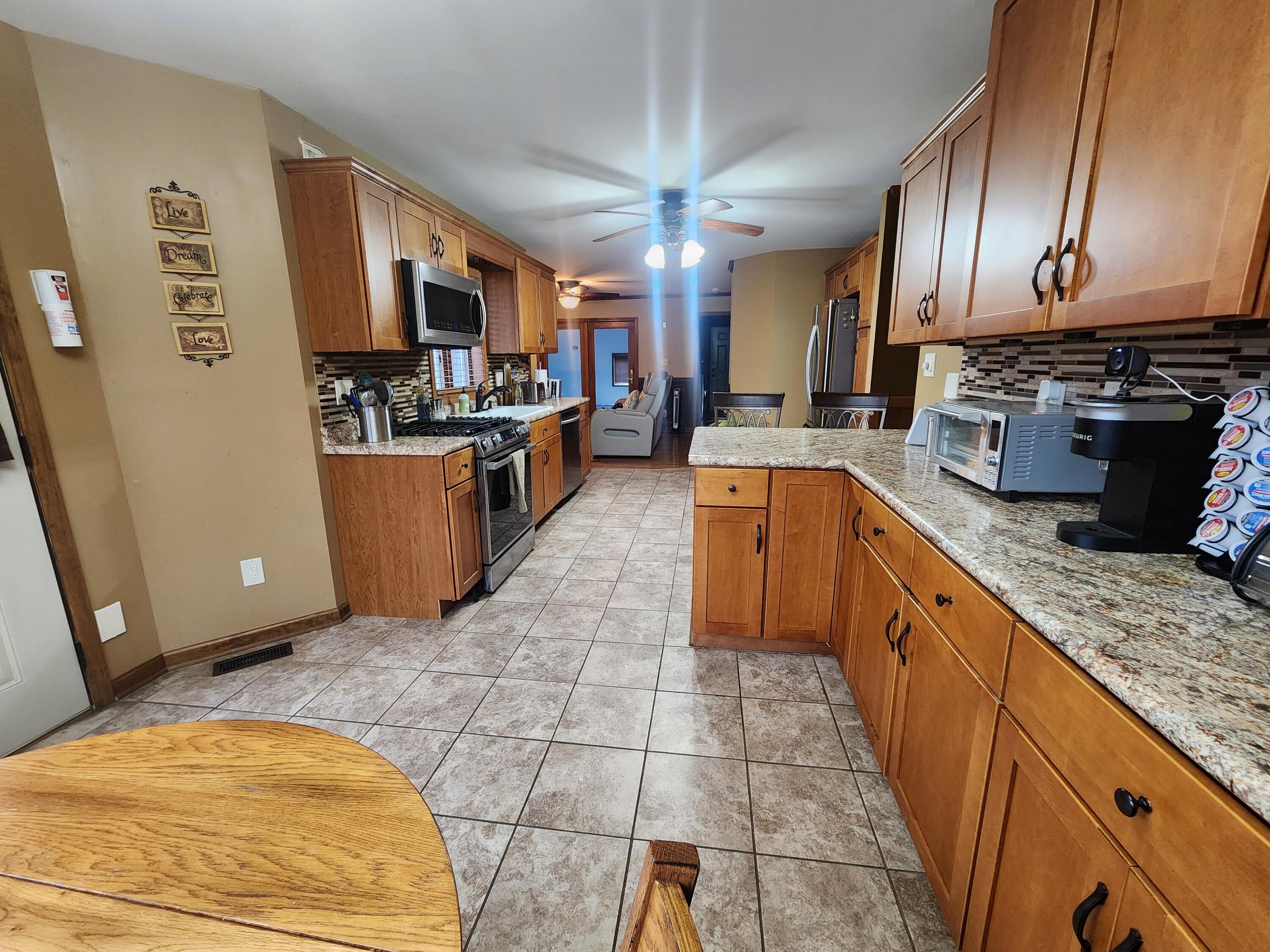 1407 Tyler Court Crown Point, IN 46307 - Photo 6 of 24 a large kitchen with stainless steel appliances granite countertop a stove a sink dishwasher and cabinets
