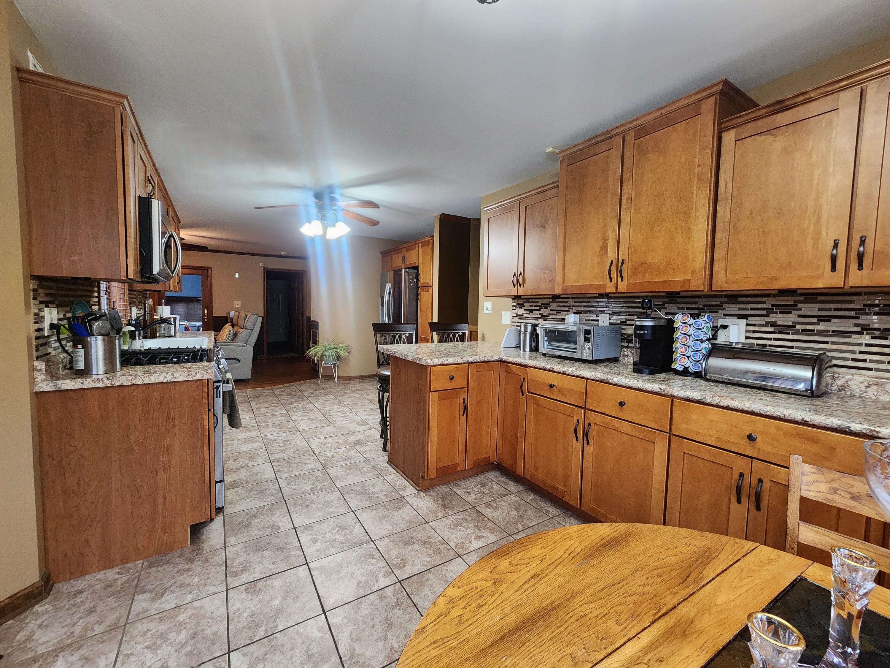 1407 Tyler Court Crown Point, IN 46307 - Photo 8 of 24 a kitchen with stainless steel appliances granite countertop a stove a sink a refrigerator and a microwave