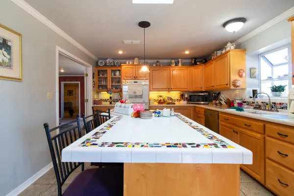 a kitchen with stainless steel appliances wooden floor dining table and chairs