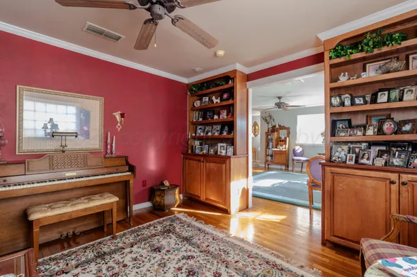 a living room with furniture a piano and a bookshelf