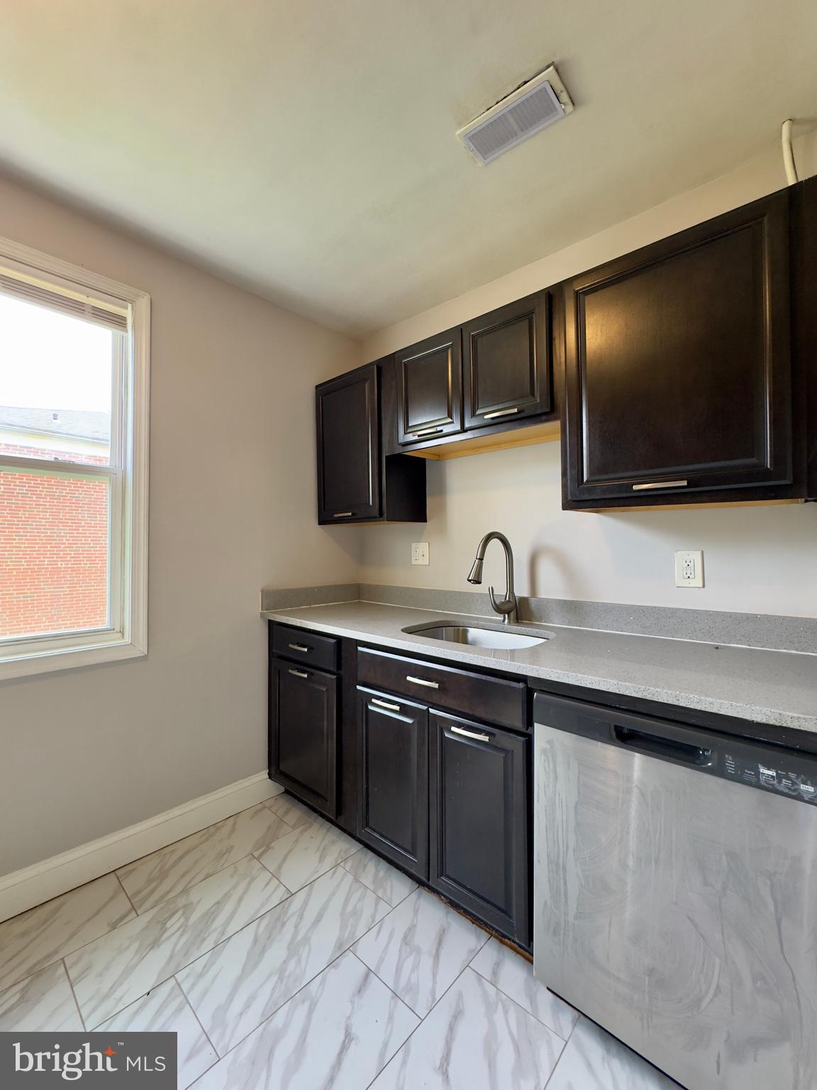 1111 Gleneagle Road, Unit 2 Baltimore, MD 21239 - Photo 4 of 11 a kitchen with stainless steel appliances granite countertop a sink and a stove top oven with wooden floor