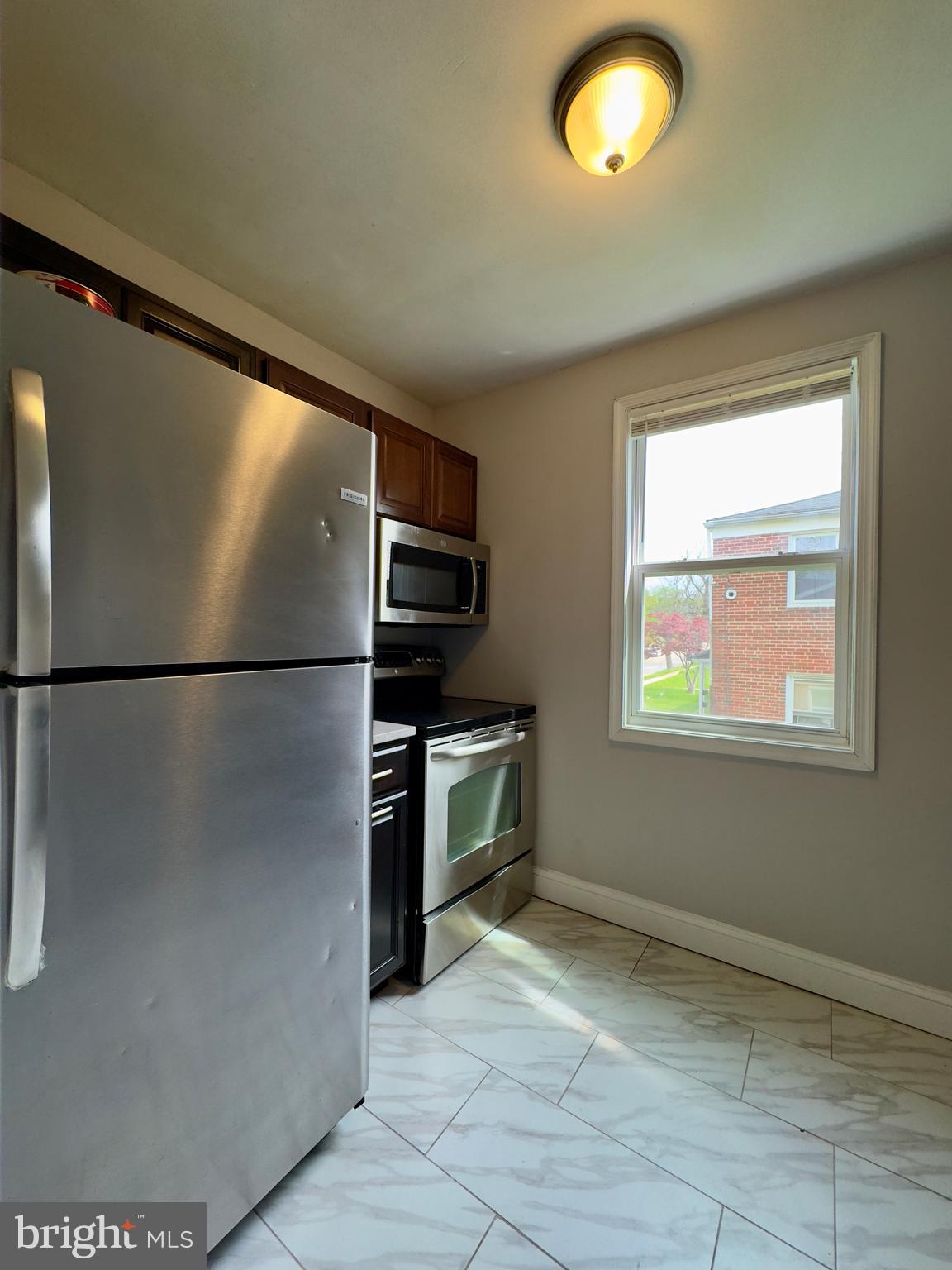 1111 Gleneagle Road, Unit 2 Baltimore, MD 21239 - Photo 5 of 11 a kitchen with granite countertop a refrigerator and a stove top oven