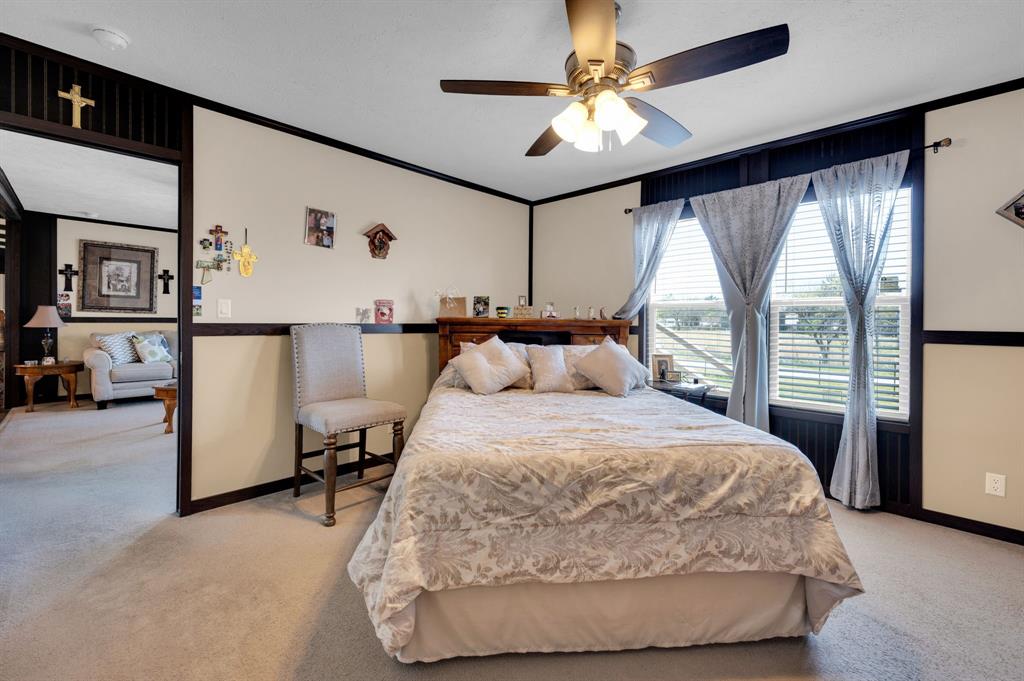 12032 County Road 0190 Rice, TX 75155 - Photo 13 of 40 a bedroom with a large bed and a chandelier