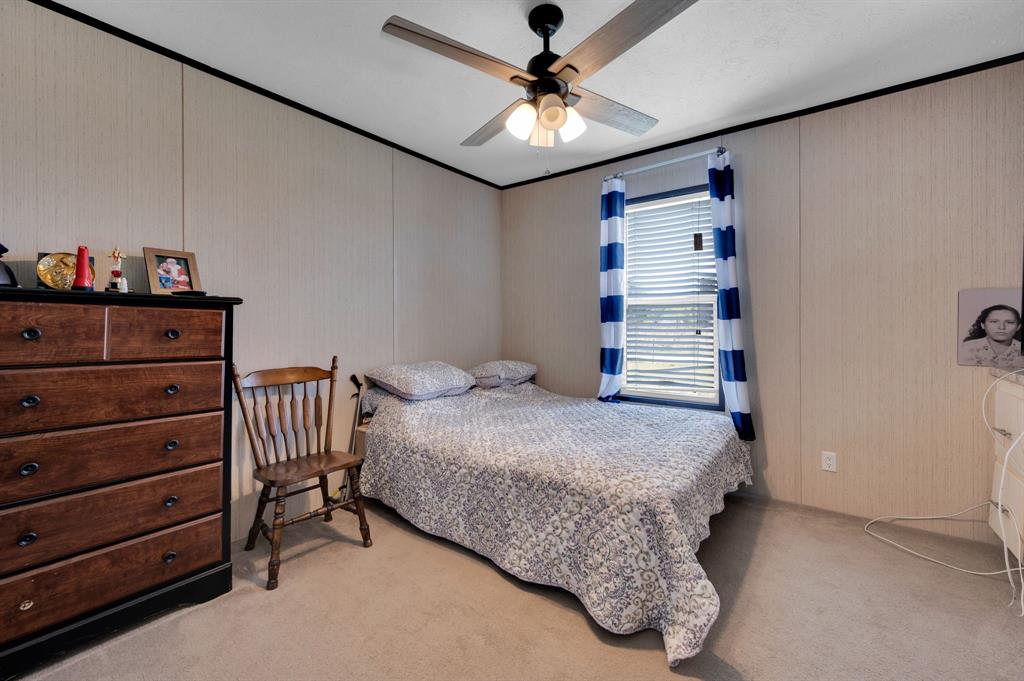 12032 County Road 0190 Rice, TX 75155 - Photo 30 of 40 a spacious bedroom with a bed and a chandelier