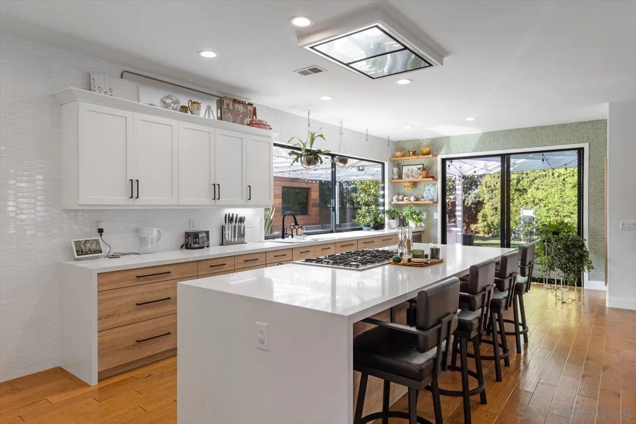 219 Jacob Lane Encinitas, CA 92024 - Photo 13 of 46 a kitchen with kitchen island granite countertop a stove a sink a dining table and chairs
