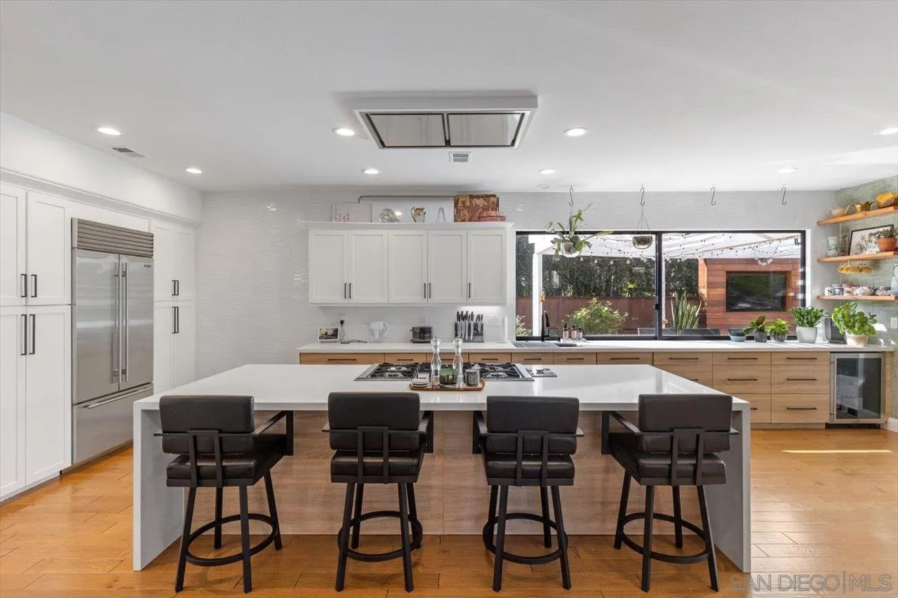 219 Jacob Lane Encinitas, CA 92024 - Photo 17 of 46 a kitchen with stainless steel appliances a dining table chairs and wooden floor
